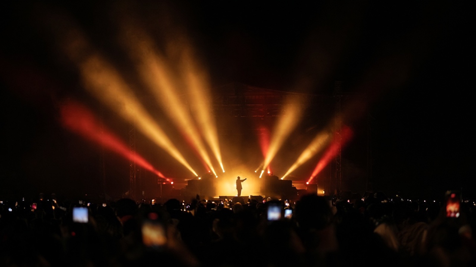 Concert stage washed in warm light beams and haze